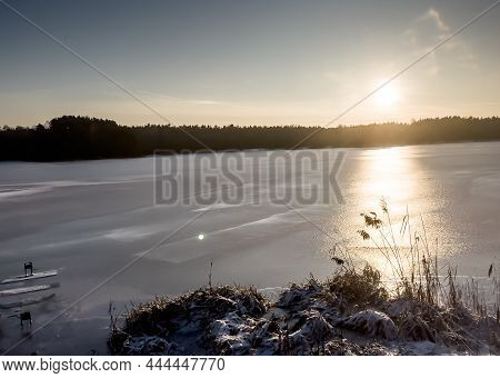 Sunset Over The Ice-covered Surface Of The Lake In Winter