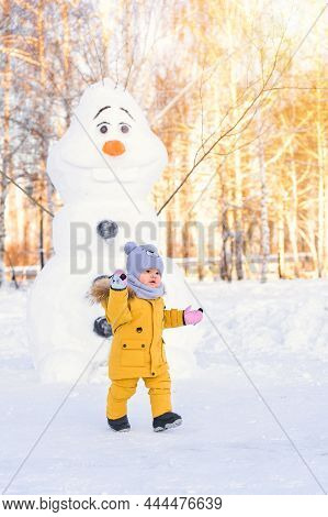 25.12.2021 Agidel Russia: Toddler 12-17 Months Old In Yellow Winter Clothes Playing In A Winter Park