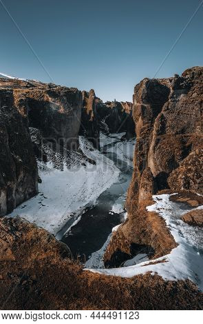 Aerial Drone View Of Fjadrargljufur Canyon And Fjadra River At Winter. White Snow And Blue River. Ic