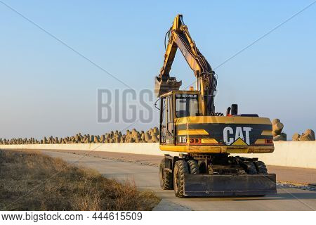 Wladyslawowo, Poland - January 27, 2017: Cat Excavator Coming Back From Construction On The Quay In 