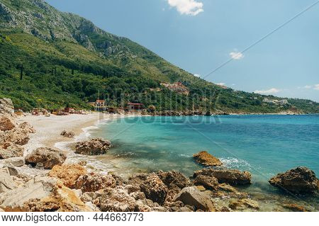 Green Cliff, Huge Boulders And Clear Water On The Drobni Pijesak Beach