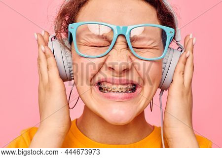 Funny Girl Wearing Blue Glasses Listening To Music On Headphones Pink Background Unaltered
