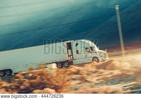 Speeding Modern Semi Trailer Truck On A Desert Highway In Southern California. Trucking Theme.
