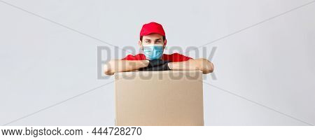 Packages And Parcels Delivery, Covid-19 Quarantine And Transfer Orders. Young Courier In Red Uniform