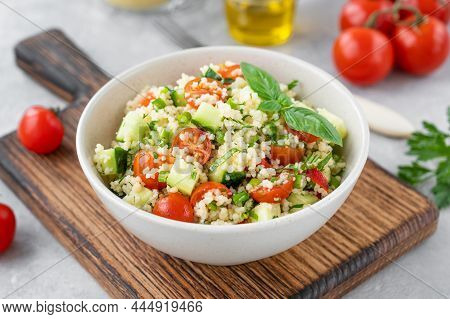 Tabbouleh Salad. Couscous Salad With Fresh Vegetables And Herbs In A Bowl On A Gray Concrete Backgro