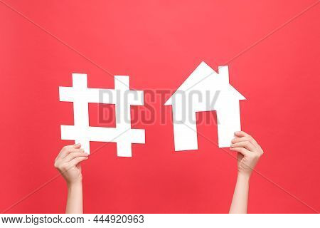 Female Hands Holding Yellow Hashtag Sign And House Model, Label For Business, Marketing, Isolated On