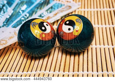 Chinese Meditation Balls And A Fan. Baoding Balls With Yin-yang Symbol