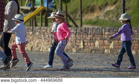 Guatavita, Cundinamarca, Colombia - November 23, 2017: A Group Of Children With Hats Walks Happily A