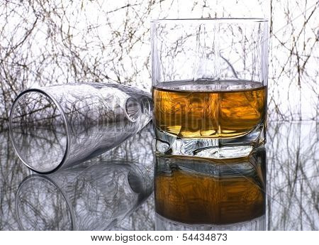 Glass of whiskey and empty glass for wine