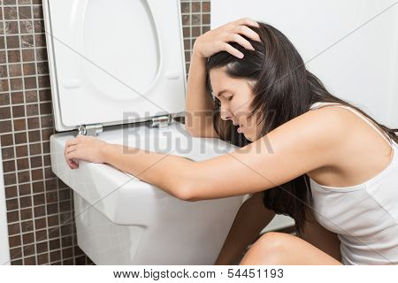Woman Vomiting Into The Toilet Bowl