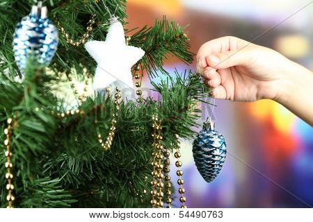 Decorating Christmas tree on bright background