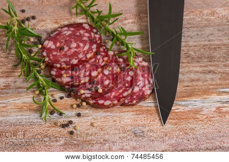 salami slices with pepper and rosemary