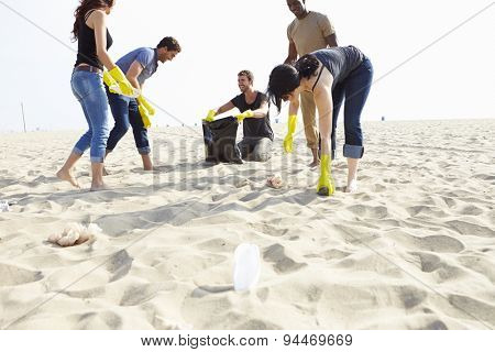 Group Of Volunteers Tidying Up Rubbish On Beach