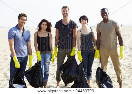 Group Of Volunteers Tidying Up Rubbish On Beach