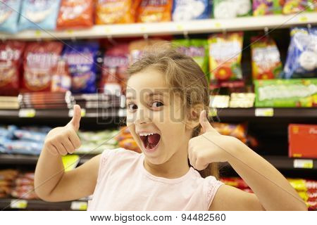 Girl in confectionery supermarket confectionery aisle