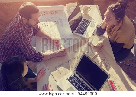 Young group of people/architects discussing business plans.