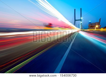 cars light trails on the modern bridge at dusk