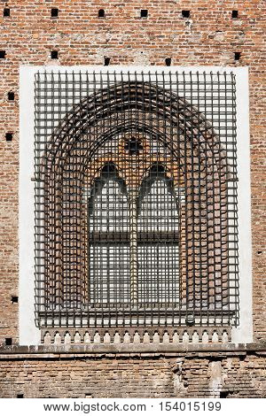 Detail of an ancient window with grating in wrought iron of the Sforza Castle XV century (Castello Sforzesco) in Milano Lombardy Italy