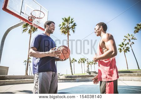Basketball player making a dunk - Sportive man doing a spectacular dunk outdoors