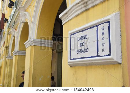 MACAU, CHINA - MAY 08, 2016 - Largo do Senado street sign on a yellow wall