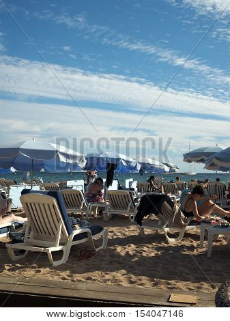CANNES-SEPT. 13: Sunbathers are seen enjoying the famous beach in Cannes France just off Promenade de la Croisette on September 13 2015.