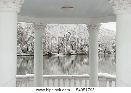 pavilion with columns on a background of the winter lake and the park