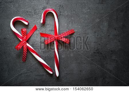 Christmas Candy canes over dark stone background. Top view with copy space