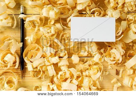Blank business card on wooden table for carpenter tools with sawdust.Copy space. Top view.