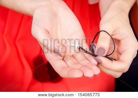A girl in red dress holding in her hands a silver  for baptism.