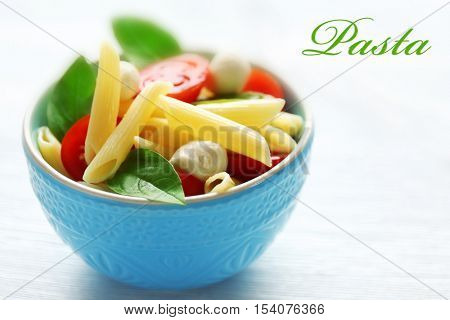 Bowl of delicious pasta, closeup. Italian food concept. Word PASTA on background.