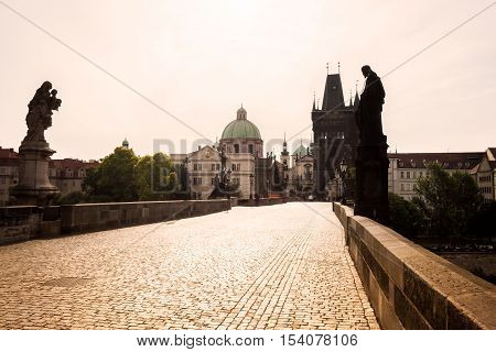 Prague, Czech Republic. Charles Bridge with its statuette, Old Town Bridge Tower, St. Francis Of Assissi Church in the background.