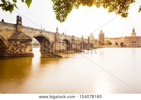 Prague, Czech Republic. Charles Bridge with its statuette, Old Town Bridge Tower, St. Francis Of Assissi Church in the background.