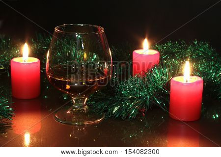 Christmas Photo Cognac Glass And Candle On Black Background