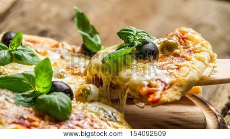 Freshly baked pizza with cheese on old wooden table