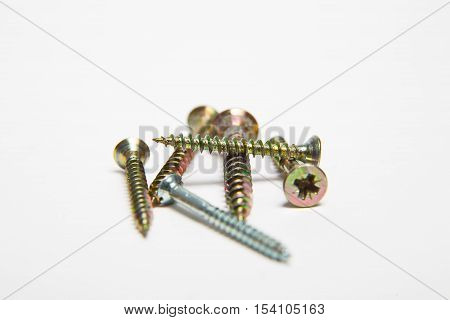 Golden and silver Screws screwed on white background