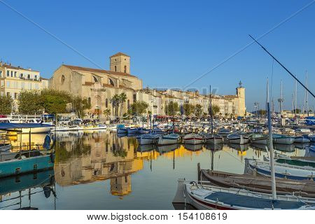 Yachts reflecting in blue water in the old town port of La Ciotat Marseilles district France in the evening light