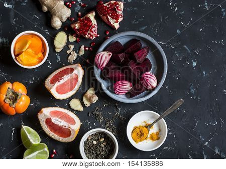 Ingredients for cooking beet and ginger detox elixir. On a dark background top view