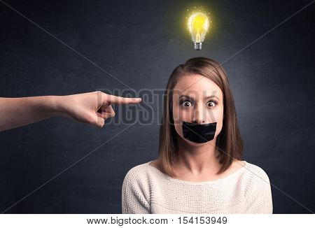Caucasian hand pointing at female employee with a lightbulb above her head