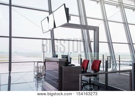 Blank monitors at departure gate. Empty departure check-in counter. Closed gate. Waiting area at airport