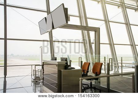 Blank monitors at departure gate. Empty departure check-in counter. Closed gate. Waiting area at airport