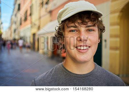 Humeral portrait of smiling teenage boy on the street.