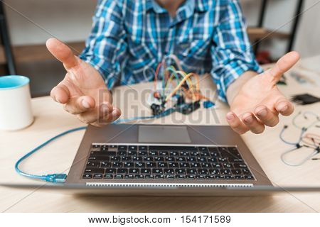 Engineer hands raised up in desperate to laptop. Bored of waiting programmer talking to hovering computer. Programming, failed connection, old technology lag