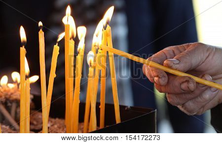 picture of a old man lights a candle