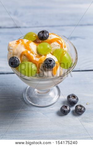 Fruit ice cream with fruits on old wooden table