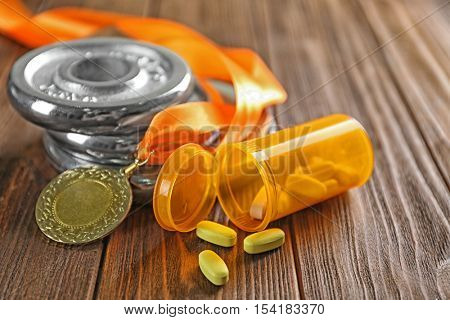 Drugs, medal and weight disks on wooden background