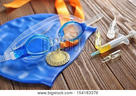 Sports equipment and syringe on wooden background