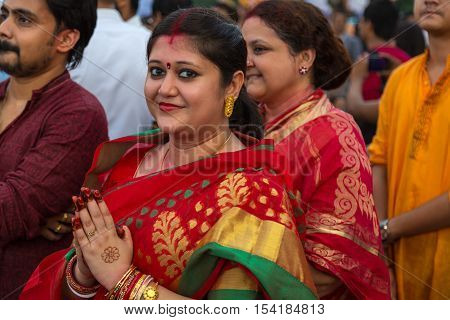 KOLKATA, INDIA - OCTOBER 10, 2016: A hindu married woman holds her hands to pay homage to Goddess Durga at the  immersion ceremony at Babughat Kolkata, West Bengal, India.