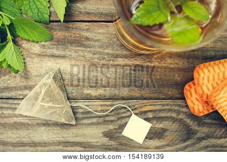 Tea bag, mint, cookie and cup of tea. Toned image. Top view.