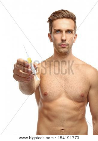 Muscular man holding syringe on white background