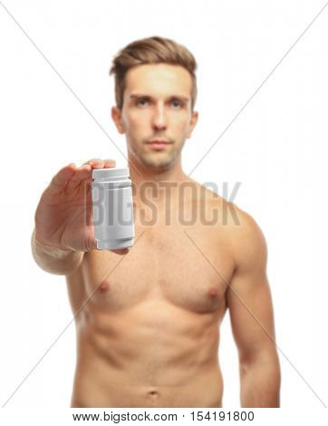 Muscular man holding drugs on white background